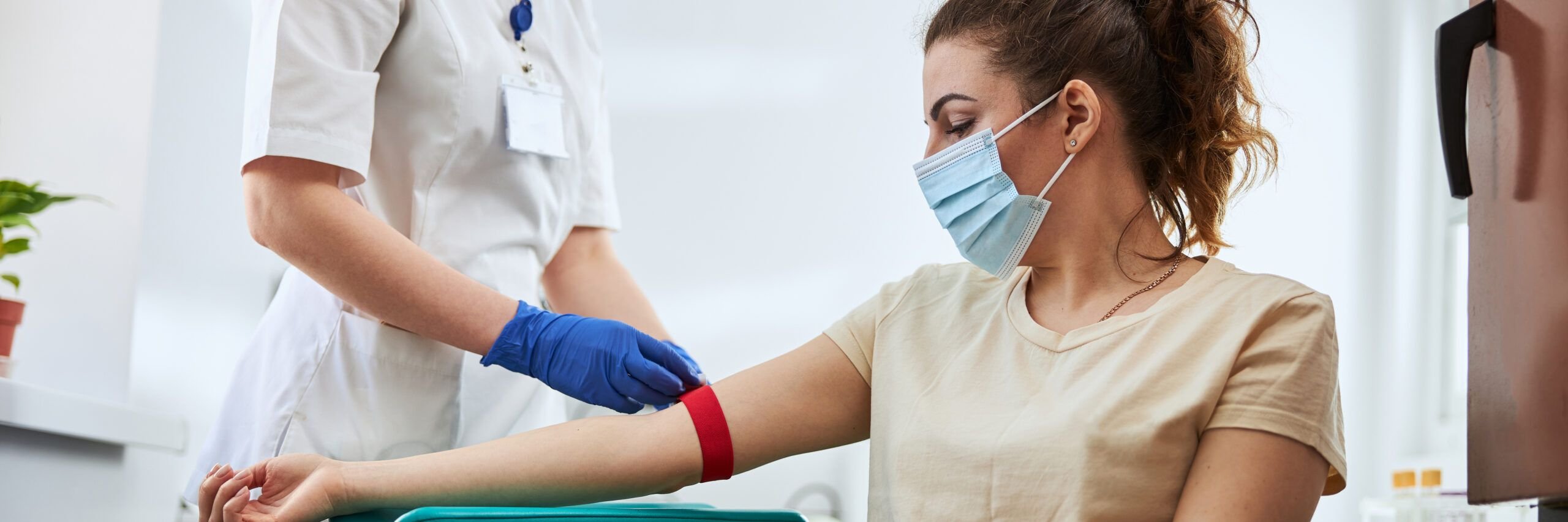 Experienced phlebotomist preparing a woman for blood draw