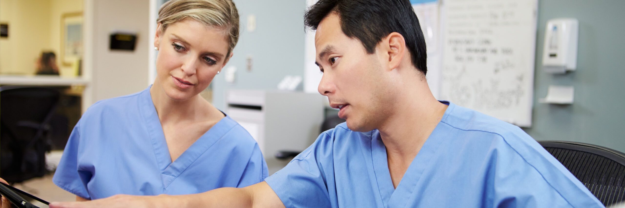 Male And Female Nurse Working At Nurses Station